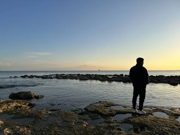 Mies Rannikolla Katselee Kohti Merta Jossa Auringonlasku Kätkee Miellyttävän Hetken — kuvapankkivalokuva
