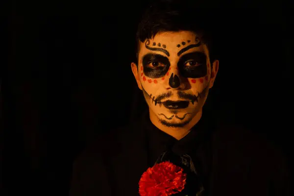 Catrin gibi giyinmiş bir adam siyah bir arka planda Meksika ölüm gününün kültürünü simgeliyor.