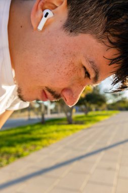 Genç sporcu, biraz aylak, yere bakıyor. Sabah biraz düşünceli.