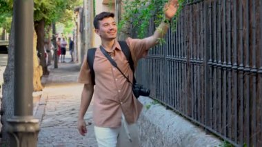 Genç fotoğrafçı güneşli bir günde Mallorca İspanya 'da Valldemosa' nın güzel sokaklarında mutlu bir şekilde yürüyor.