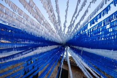 Şehirden uzak bir kasabanın sokaklarına bakan beyaz ve mavi flamalar bize yıl boyunca kutlamalar ve şenlikler havası veriyor.