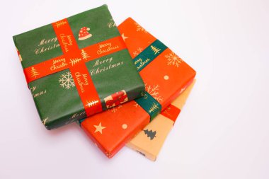 Beyaz arka plan, Noel hediyeleri ve Noel mevsimi konseptine yerleştirilmiş çeşitli renklerde üç Noel hediyesi.
