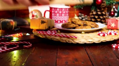 Erkek el, üzerinde kara Cuma yazılı sarı bir kağıt olan ahşap bir masaya üç Noel hediyesi koyuyor. Noel zamanı ve Kara Cuma kavramı