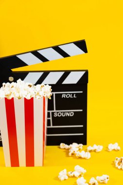 Patlamış mısırın dikey görüntüsü ahşap film alfabesiyle arka planda patlamış mısır, sinema ve eğlence konsepti.