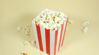 Erkek el, kırmızı beyaz karton bir kovadan patlamış mısır ve patlamış mısır konseptini alıyor.