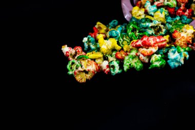 Siyah arka plan, sinema ve patlamış mısır kavramına dağılmış renkli patlamış mısırlara yakın çekim