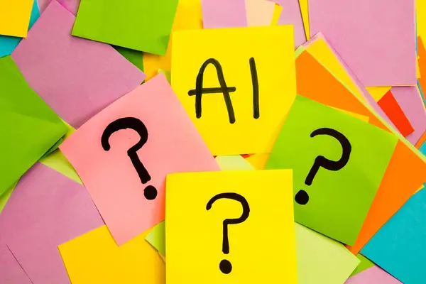 Üzerinde siyah harf olan sarı yapışkan kağıt üzerinde yapay zeka, üzerinde soru işaretleri olan renkli kağıtlar, yapay zeka ve gelecekle ilgili soru kavramı.