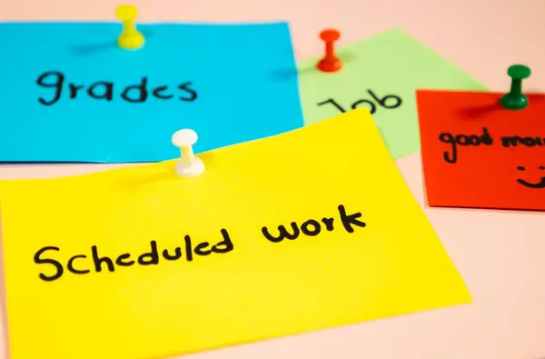 Pembe arka planda renkli raptiyelerle yapıştırılmış iş mesajları olan çok renkli kağıtları kapat