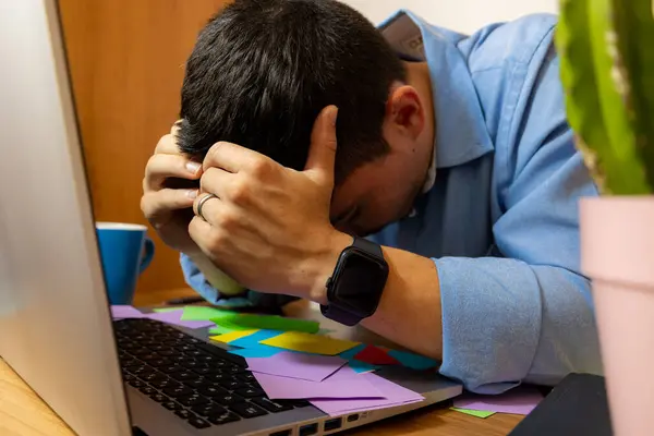 Ofiste çok fazla iş olduğu için ellerini masanın üstüne koyan genç adama yakın dur. Ofiste çok fazla iş olduğu için.