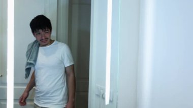 Yeni uyanmış bir adamın videosu. Banyodaki aynanın önünde dişlerini fırçalaması, kişisel hijyen...