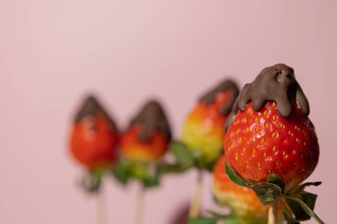 Close up of strawberries with melted chocolate on a pink background with copy space, Valentine's Day food concept clipart