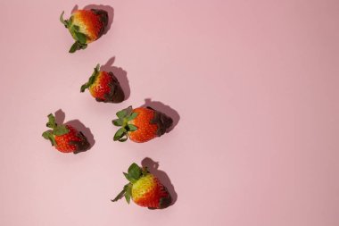 top view of strawberries with melted chocolate spread on pink background with copy space, valentines day food concept clipart