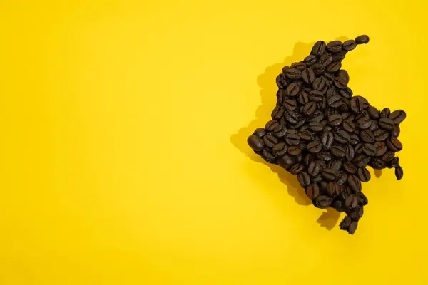 Kolombiya haritası şeklinde kahve çekirdekleri sarı arka planda, Kolombiya kahvesi kavramı