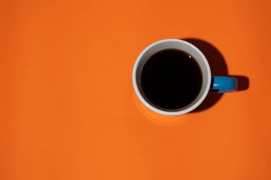 Minimalist turuncu arkaplandaki mavi kupanın üst görünümü