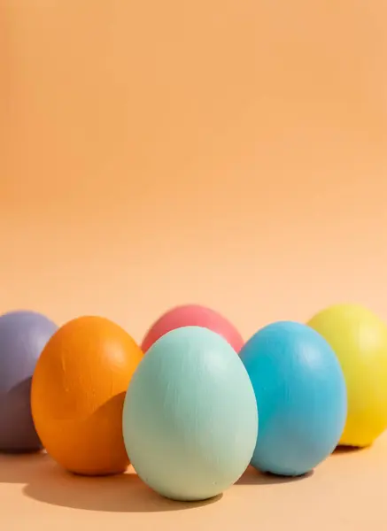 Çok renkli paskalya yumurtalarının dikey görüntüsünü hafif bir arkaplanda kapat, Paskalya kutlaması konsepti