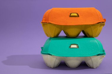 İki renkli yumurta sepeti, mor arka planda fotokopi alanı ile istiflenmiş. Paskalya dekorasyonu