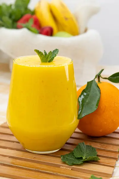 Cam bardaktaki portakal suyunun dikey görüntüsü. C vitamini bakımından zengin sağlıklı tropik meyve suyu. Besleyici meyve suyu.