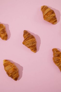 Ay çöreklerinin dikey görüntüsü minimalist bir pastel üzerine saçılmış pembe arka plan, pofuduk pastane parçası