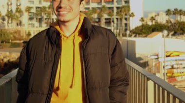 Neşeli adam güneşli bir günde yürüyor, açık havada.