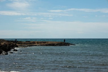 Güneşli bir günde, arka planda ufuk olan açık mavi gökyüzü ile Akdeniz kıyıları