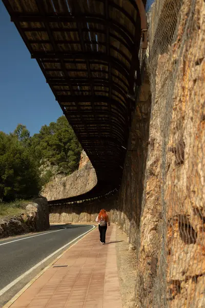 Güneşli bir günde yalnız bir yolda yürüyen bir kadının bakış açısı.