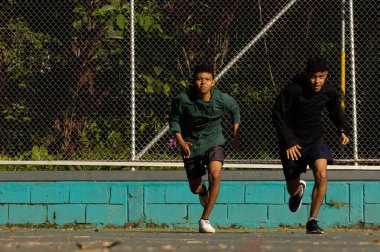 Güneşli bir günde sahada yarışan iki esmer Latin sporcu sağlıklı bir yaşam tarzına sahipler.