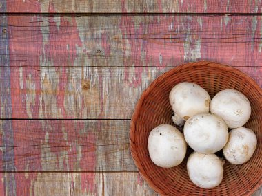 Ahşap arka planda kasede mantarlar