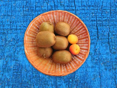 Ahşap arka planda kivi ve kayısı.