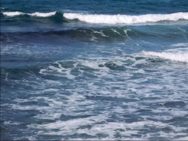 Mavi dalgalı ve beyaz köpüklü deniz suyu yüzeyi 