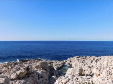 Kayalık kıyı şeridi, mavi deniz ve gökyüzü olan güzel bir manzara. 