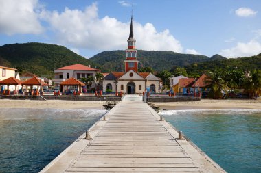 The Saint-Henri church of Anses-d'Arlet, near the beach, is known as one of the most beautiful sites of Martinique, in particular because of its exact alignment with the pontoon.