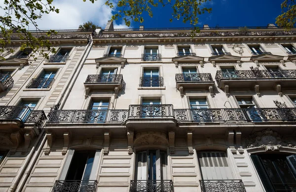 The facade of traditional French house with typical balconies and windows. Paris, France.
