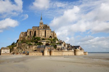 Mont Saint-Michel gelgit adası, Fransa 'da Normandiya ve Brittany arasındaki sınırda, yeşil çayırlar ve mavi gökyüzü ile. Fransa.