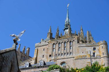 Mont Saint-Michel gelgit adası, Fransa 'da Normandiya ve Brittany arasındaki sınırda, yeşil çayırlar ve mavi gökyüzü ile. Fransa.