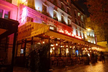 Paris Fransa-18 Ekim 2018: Yağmurlu bir akşamda Au pied du cochon adlı ünlü restoran. Paris 'in Les Halles bölgesinde yer almaktadır. Neon ışıkları 1947 'den beri kapanmadı..