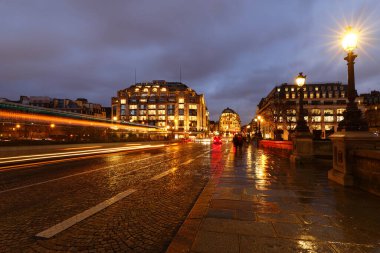Paris at rainy night cityscape. The view from Pont Neuf bridge.