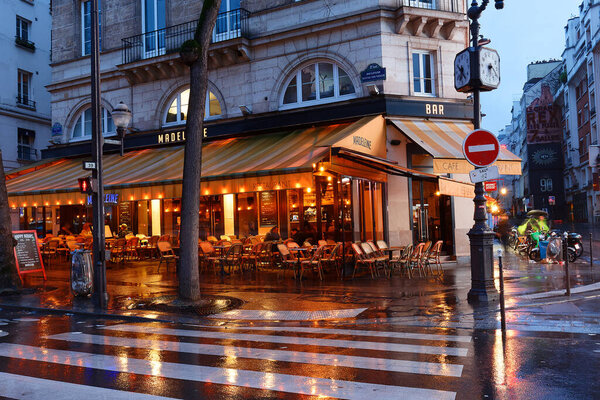 Paris, France-February 24, 2024 : Madeleine is traditional French cafe at rainy night . It located at Boulevard Bonne Nouvelle near Porte Saint Denis in Paris, France.