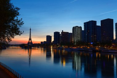 Paris, Fransa 'da gün batımında Eyfel Kulesi ve Seine Nehri manzarası. Eyfel Kulesi, Paris 'in en ikonik simgelerinden biridir.