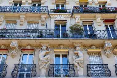 The facade of traditional French house with typical balconies and windows. Paris, France. clipart