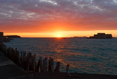 Saint Malo, Brittany, Fransa 'da kışın Atlantik Okyanusu üzerinde renkli günbatımı gökyüzü.