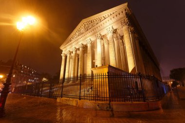 The view of the Roman Catholic church Madeleine at rainy night , Paris, France clipart