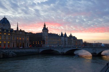 Paris city historic center with Pont au Change bridge across Seine river, Conciergerie palace Gothic revival architecture style at sunset twilight, Paris evening view, France clipart