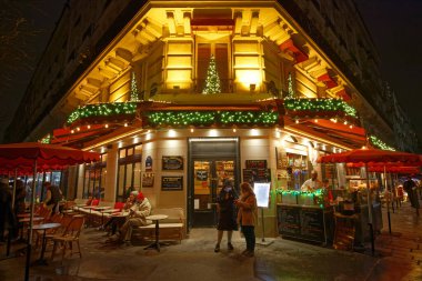 PARIS, FRANCE - 14 Aralık 2024: Geceleri ünlü Notre Dame katedralinin yanındaki tipik Paris restoranı ..