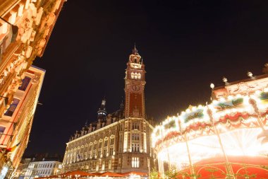 Lille Ticaret Odası 'nın çan kulesi geceleri Noel pazarına bakıyor. Fransa.