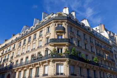 Paris 'te tipik balkonları ve pencereleri olan geleneksel Fransız evinin dış mimarisi. Ön planda geleneksel Paris sokak lambası.