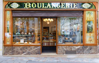 Paris, Fransa-22 Nisan 2025: Paris 'in 12. bölgesinde bulunan klasik fırın ve pasta dükkanı. Ön tarafta, cam altında altın yapraklı ahşap süslemeler var..