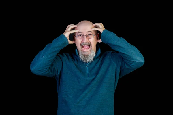 bald middle age man with goatee sick using headache medication and angry on black background