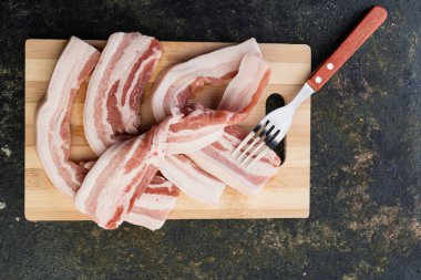 Tahtada baharatlı ve otlu çiğ domuz pirzolası.