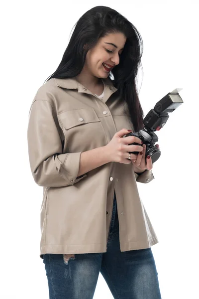 女摄影师穿着牛仔裤和棕色皮夹克 穿着白色背景的衣服在摄影棚拍照 照像机会话 — 图库照片