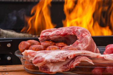 Sosis, tavuk budu, domuz pastırması, domuz kaburgası, sosis ve sebzelerle birlikte açık havada ızgarada kızartılmış et, odun ateşi ve mangal kömürü, duman..